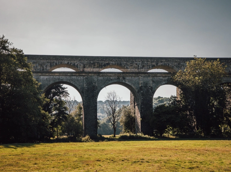 Two viaducts running parallel to each other surrounded by trees.