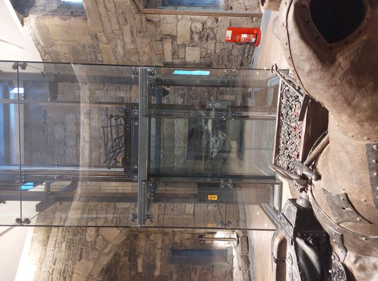 A glass lift inside a castle.
