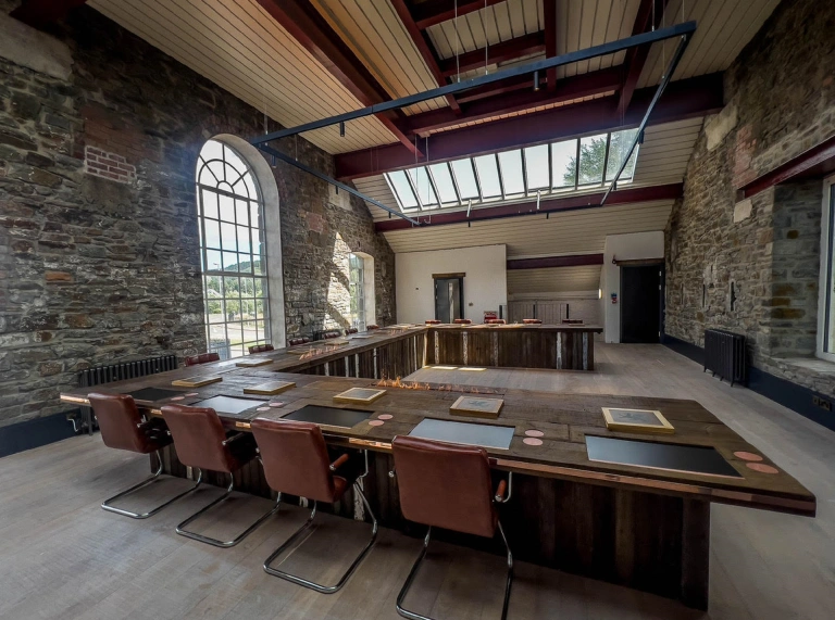 A room set up with tables and chairs for a whisky tasting masterclass.