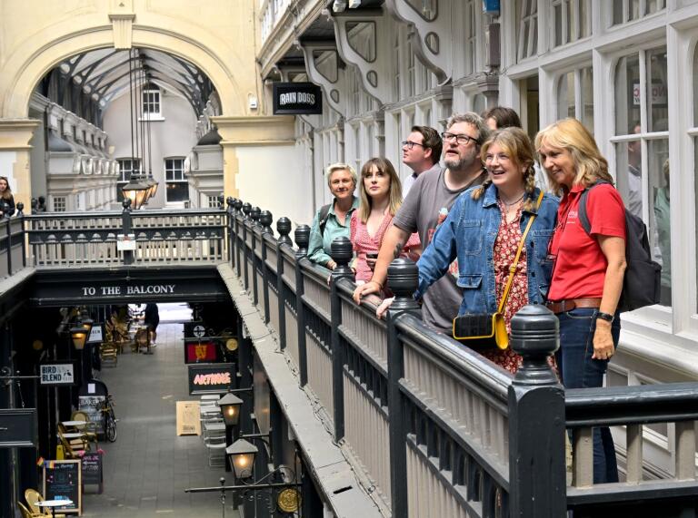 Group of people on a balcony in a shopping arcade.