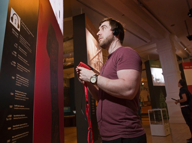 A man reading facts in a museum whilst interacting with the app.