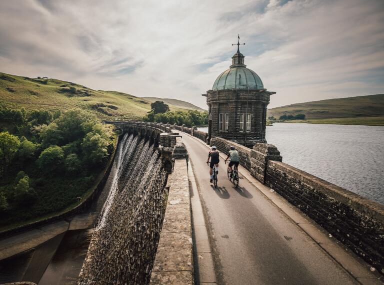 Cyclists going across a dam.