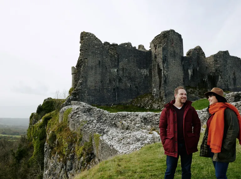 A couple exploring a castle on a hill.