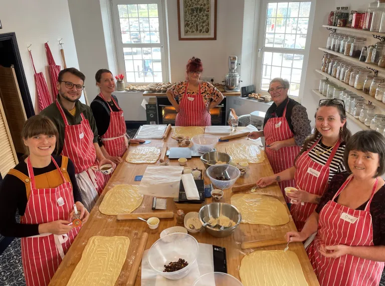 Group of people making bread at a baker school.