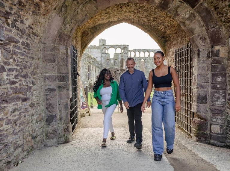 Group of people walking around the ruins of a bishop's palace.