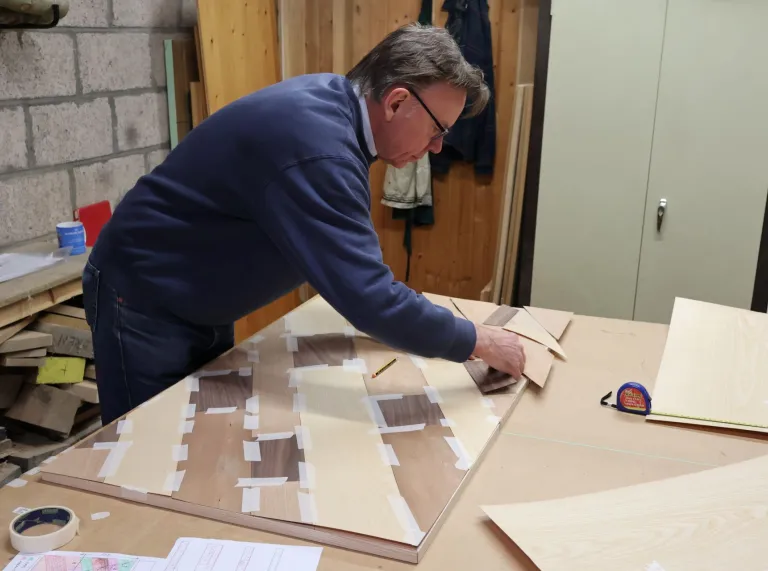 A man doing marquetry in a workshop.