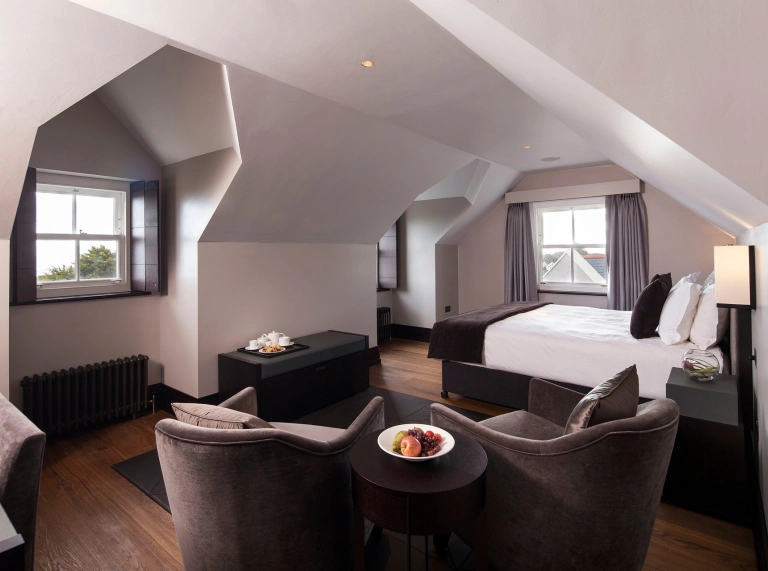 A comfy hotel room surrounded by windows.