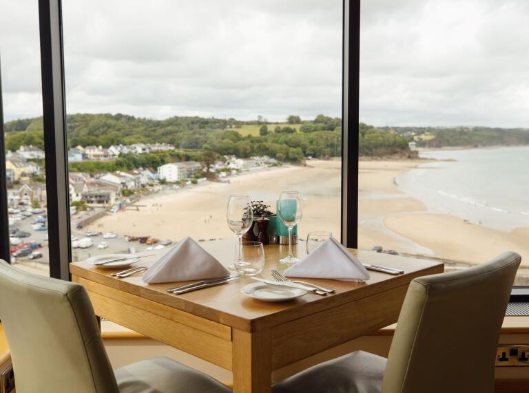 A dining table in a hotel overlooking the coast.