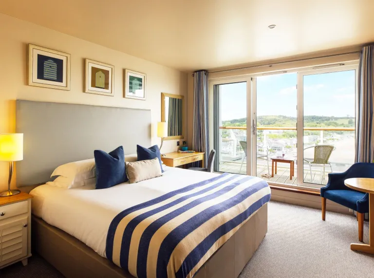 A bedroom with a balcony and sea view.