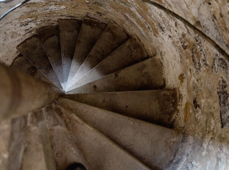 A stone spiral staircase in a palace.