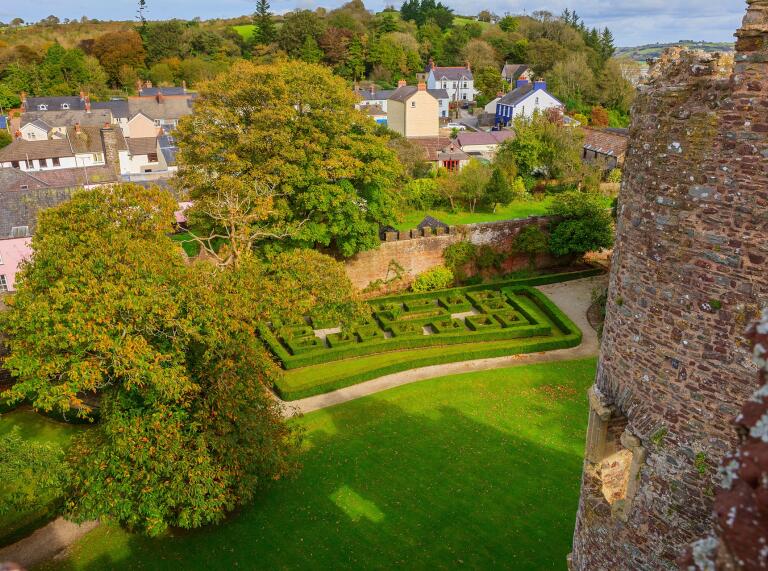 Ornamental gardens seen from a tower in a castle.
