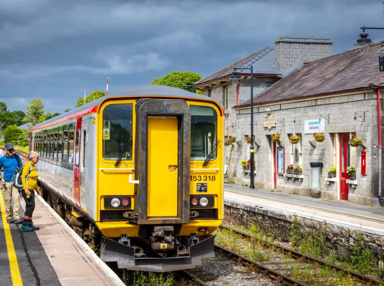 Walkers boarding a train at a station.