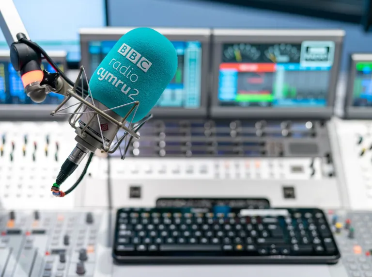 A mic behind a mixing desk at a broadcasting studio