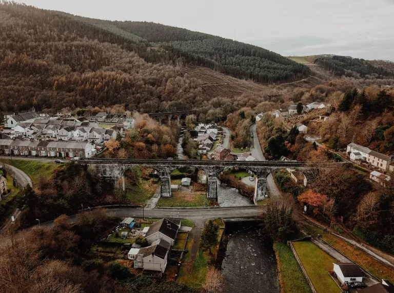 A viaduct over a river with a village in the background