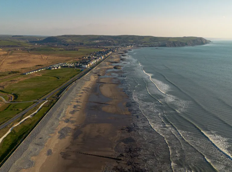 Aerial shot of a golf course alongside a coastline.