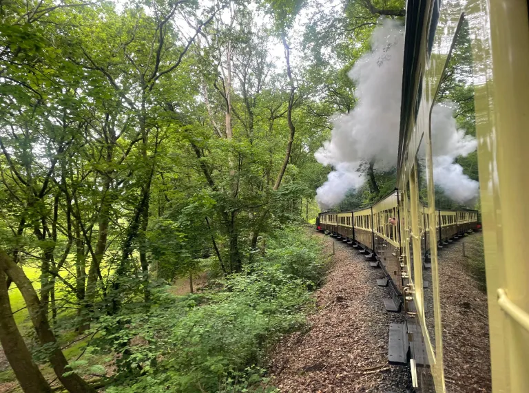 View from a carriage of a steam train travelling around a bend.