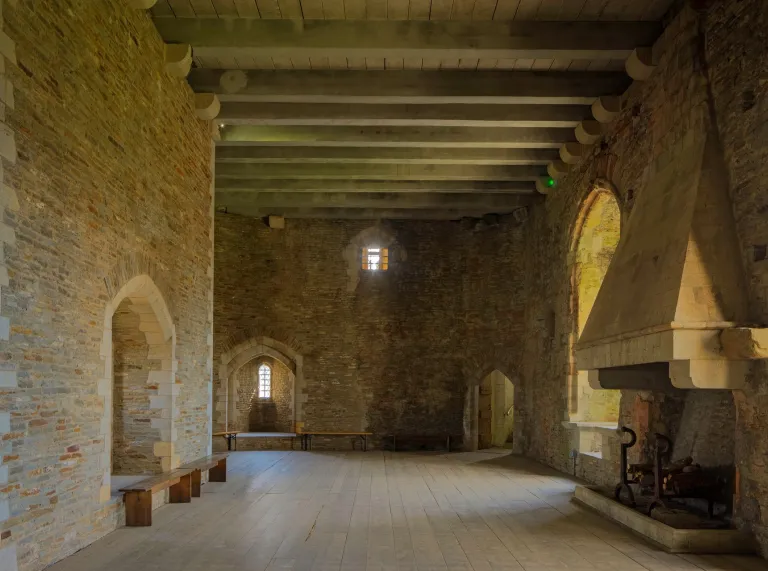 A grand fireplace inside the walls of a castle.