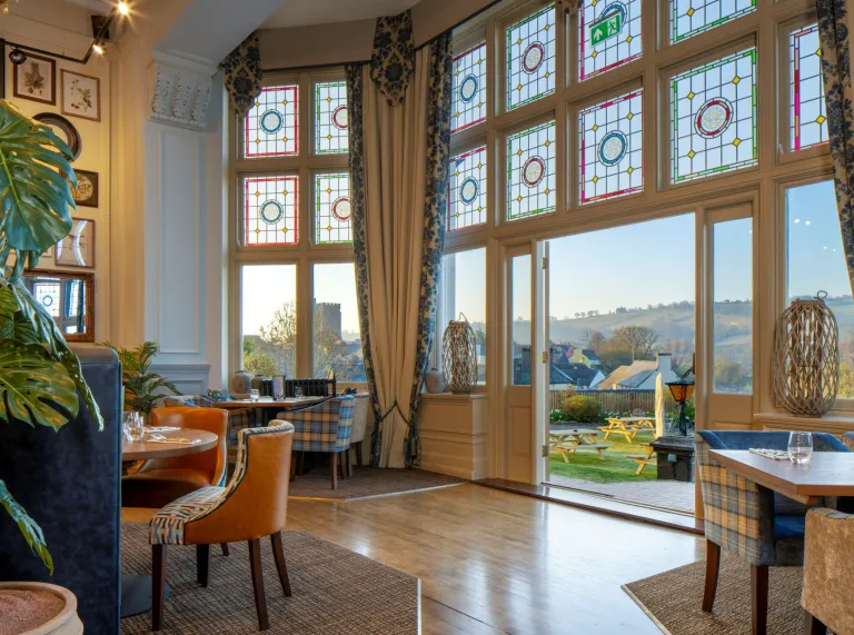 A restuarant in a hotel with big windows overlooking the town and cathedral.