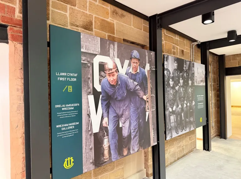 Display boards of historic miners and guards in a museum.