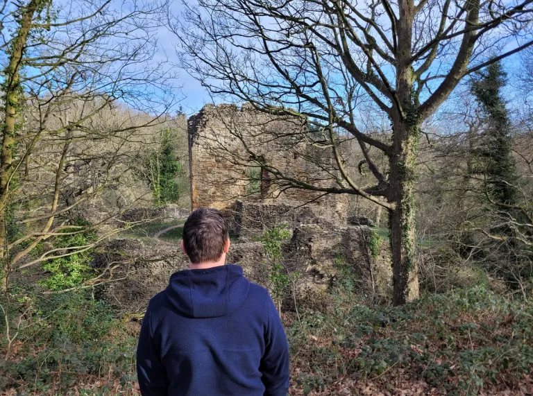 A man looking at the ruins of an historic building.