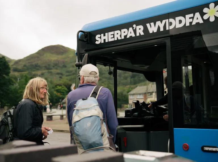 Two people boarding the Sherpa bus.
