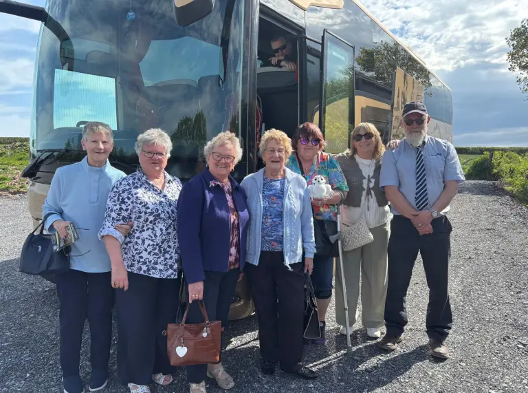 A group in front of a coach.