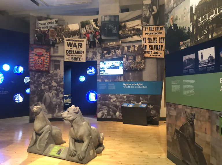 Information poster boards and replica stone animals in a museum.