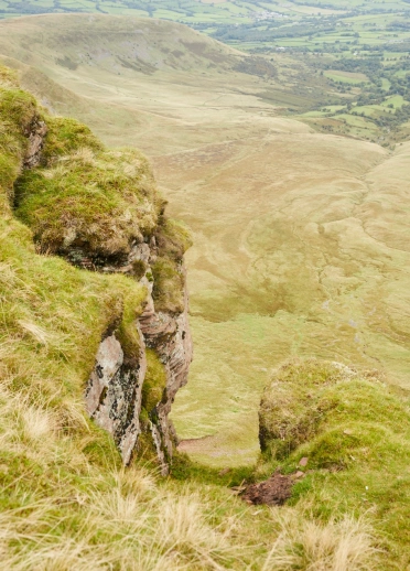 A rocky ridge on a mountain with views of the valley below.