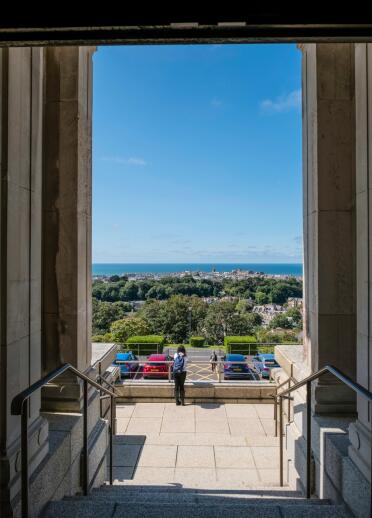 View of the sea beyond from the steps and entrance of a national library.