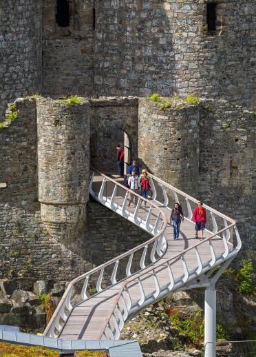 Visitors walking along the bridge to Harlech Castle.