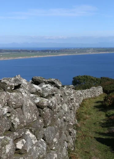 A view Hell's Mouth Bay's sea and coastline from a stone wall.