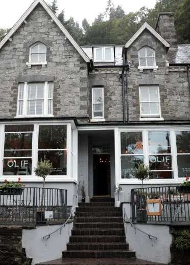 Exterior shot of Olif tapas bar with the entrance between two bay windows.