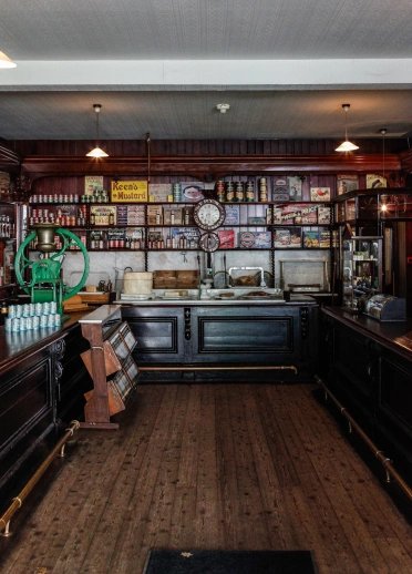 Inside an historical grocery shop with food on display on shelves and the counters.