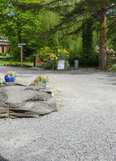 The upper entrance area at Centre for Alternative Technology with a pond and flowers.