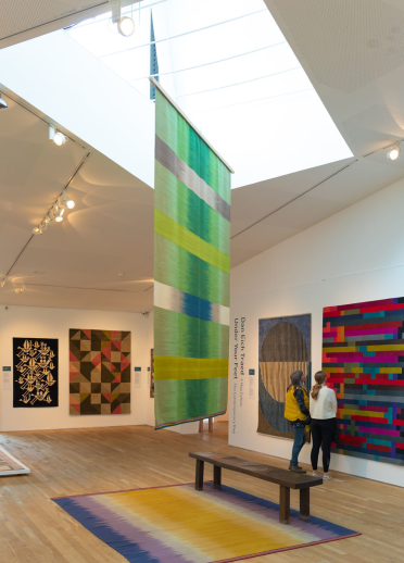 Two females looking at the wall and hanging displays at Ruthin Craft Centre.