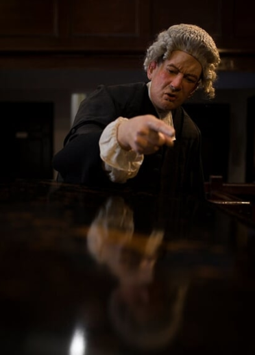 lifesize figure of judge with wig sat at table with reflection.