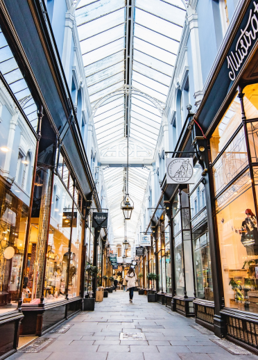 A view showing the length of Mogan Arcade with shop windows and glass paned roof.
