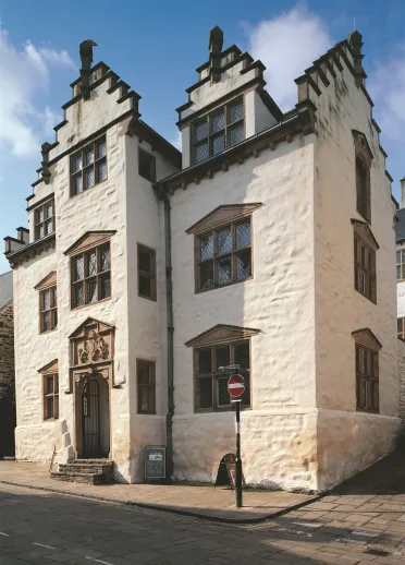 Exterior shot of the whitewashed stone walls and victorian windows of Plas Mawr.