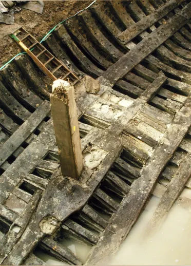 Excavating the hull of a medieval ship from the mud.
