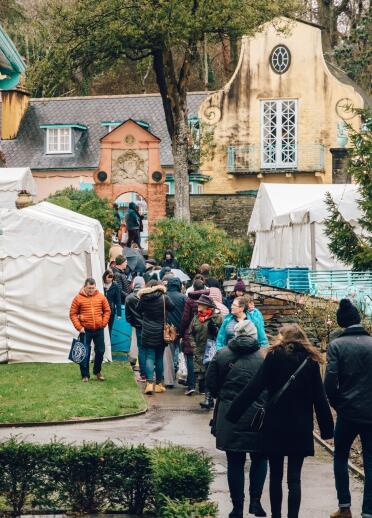 People walking around a food festival in an Italianate village.