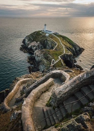 Steps leading to a lighthouse at the end of an island.