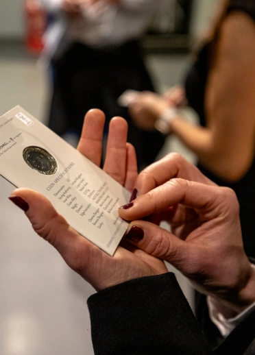 A lady holding a coin in a presentation pack.