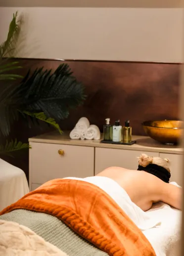 A lady on a treatment bed in a spa.