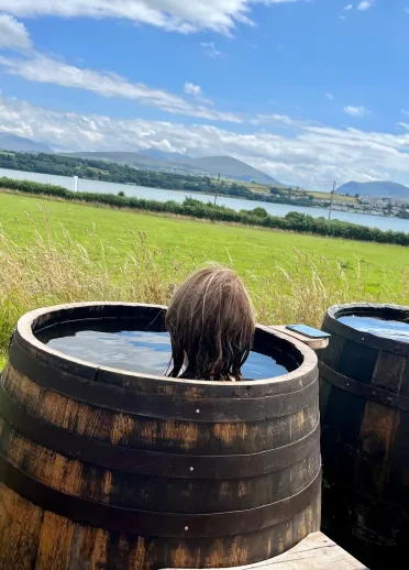 Two guests having a soak in a seaweed bath barrel.