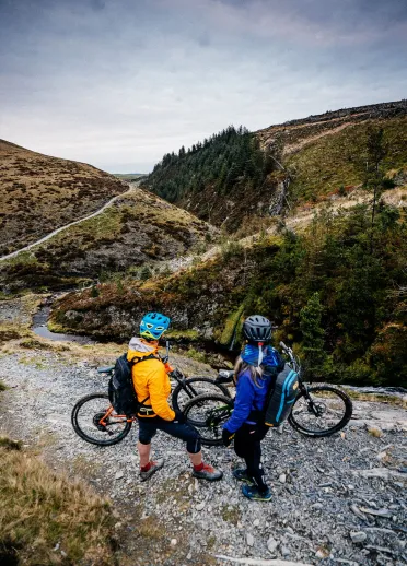 Cyclists looking at views of the mountains from cycling tracks.