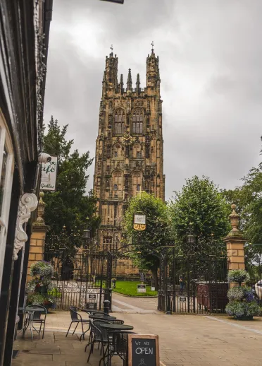 A street leading to a church with a magnificent tower.