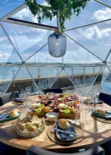 Food on a circular table for six in a dome overlooking the waterfront.