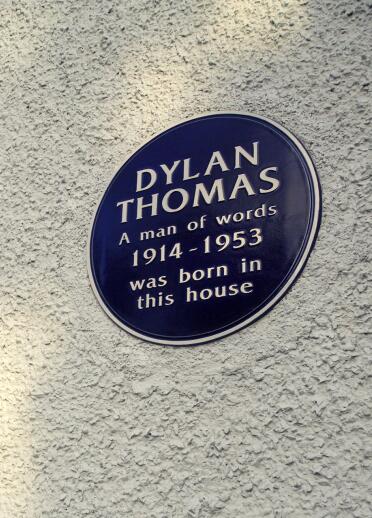 A blue plaque on the wall stating Dylan Thomas was 'born in this house'.