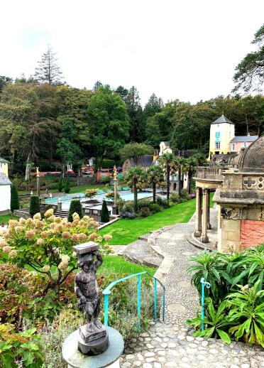 Palm trees, a lake, statue and Hydrangea, surrounded by the italianate village of Portmeirion.