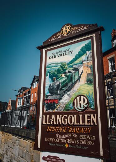 A billboard with a vintage poster of a steam heritage railway.